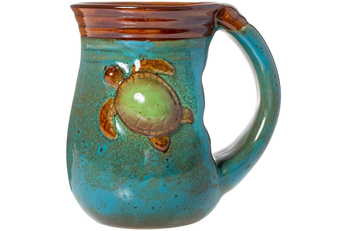A hand-crafted mug with an aquatic theme, featuring a drawing of a sea turtle.