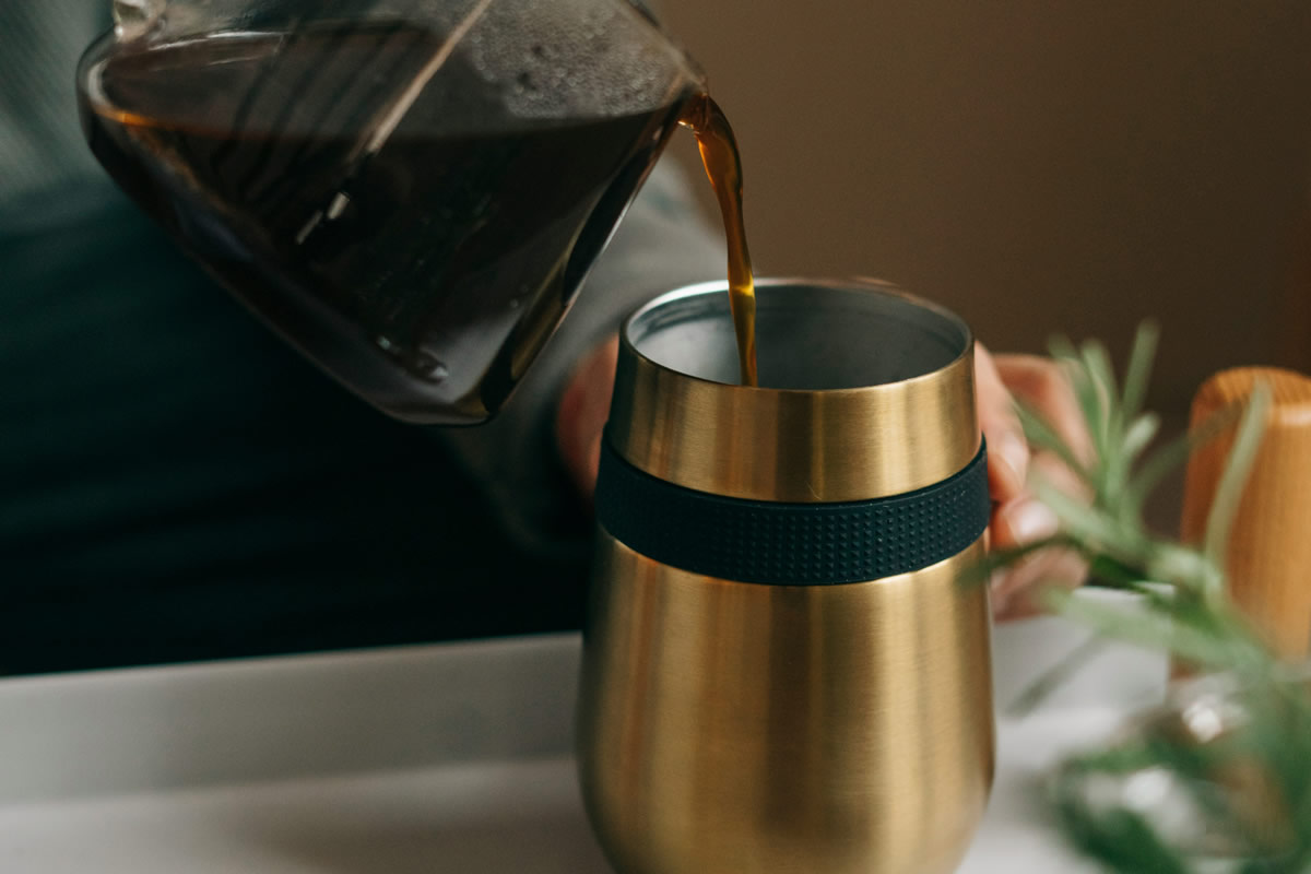 Pouring coffee into a travel mug for your daily routine.