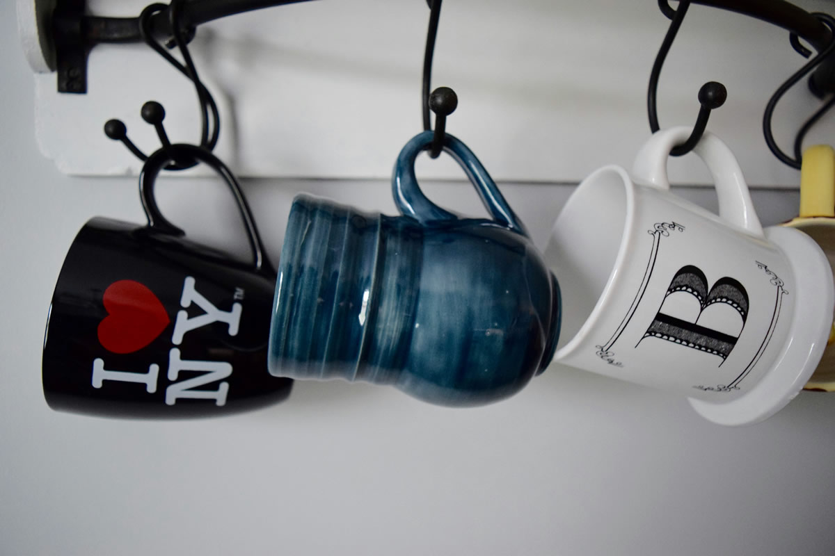 Тhree mugs hanging to dry in the kitchen.